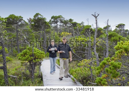 Family on Boardwalk studying Plants in a Bog, Canada