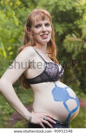 Pregnant Woman with painted Soccer Ball on Belly â?? Germany, Europe