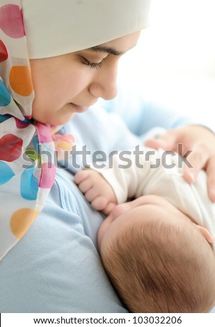 Beautiful baby of two months old in his muslim mothers hands.