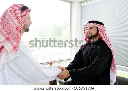 Successful Arabic business people shaking hands over a deal