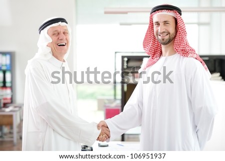 Successful Arabic business people shaking hands over a deal in office
