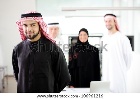 Confident muslim  young business executive with his team in the background