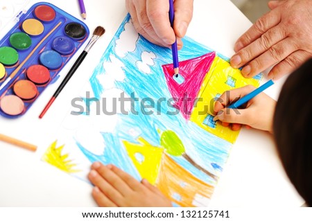 child with friends painting on paper the house