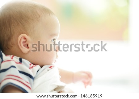 Woman holding her cute baby indoors, looking inside