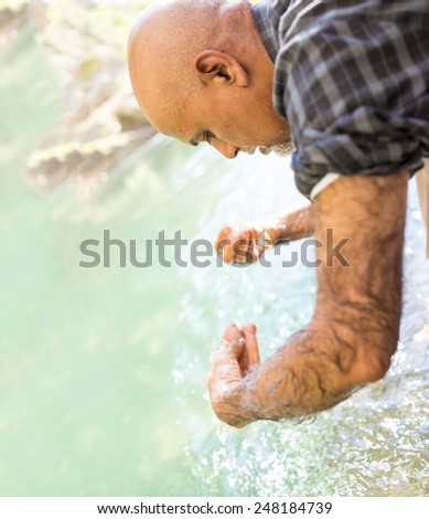 Senior Arabic Pakistani man having islamic religious rite ceremony of ablution face washing