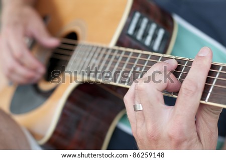 Guitar player is taking a chord on his guitar.