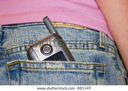 Cell phone, with camera, in the pocket of teenager.