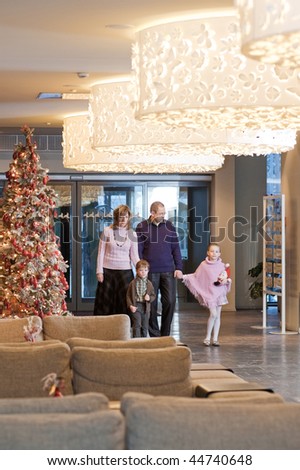 Happy family walking at foyer in the modern hotel