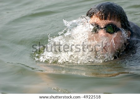 Young boy swimming with face obscured by water and goggles