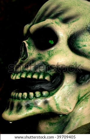 Wet and bony skeleton head of a zombie ready to grab someone on Halloween