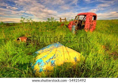 Abandoned and very old truck covered with rust and peeling pain in a field
