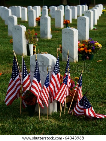 Tombstones at Arlington National Cemetery with flags and flowers