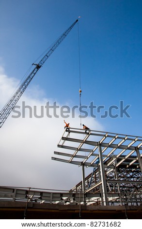 Dramatic Silhouette of Steel Workers and Crane at Construction Site
