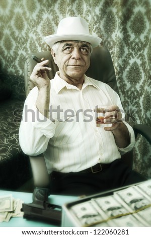 Old happy man pensively smoking a cigar