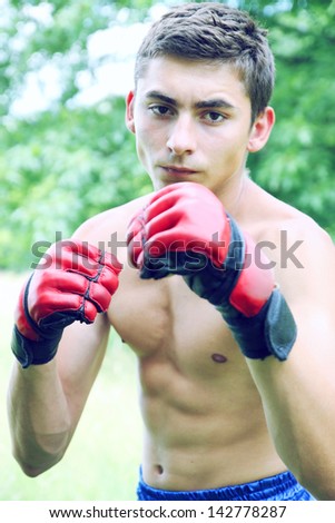 Kickboxer in red gloves engaged on the nature
