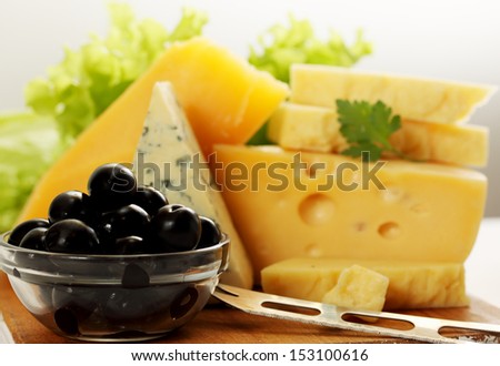 Still life of different types of cheese with olives