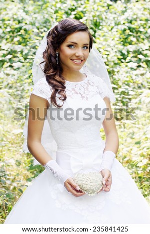Bride is holding a vintage heart decorated with pearls