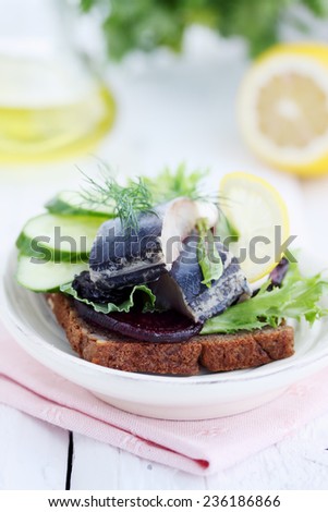 herring with cucumber and lemon on a piece of bread
