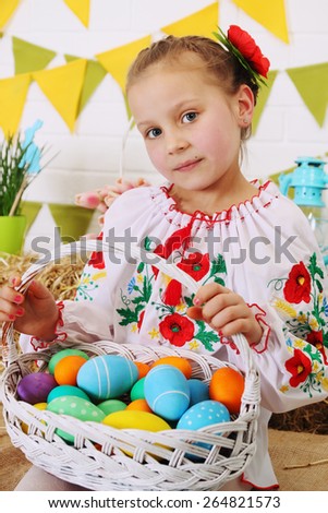 Girl with a basket of colored eggs