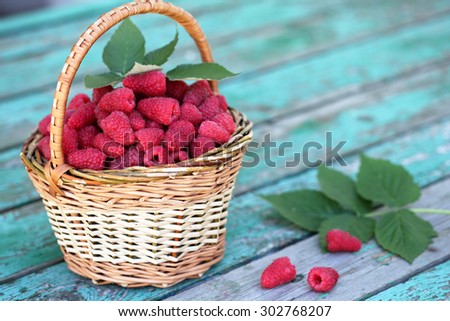Ripe juicy raspberries in a wicker basket