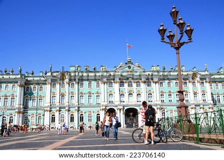 RUSSIAN, SAINT - PETERSBURG - JULY 17, 2014: Tourists at the Palace Square on the background of the Winter Palace (Hermitage).