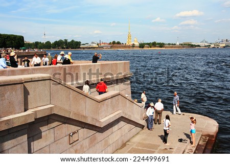 RUSSIAN, SAINT - PETERSBURG - JULY 15, 2014: Tourists look at the Peter and Paul Fortress with the Spit of Vasilievsky Island.