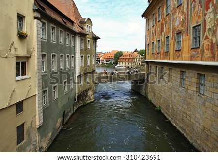 GERMANY.  BAMBERG - JUNE 26, 2015: Tourists walk on the old bridge over the River Regnitz in the historic district of the city.