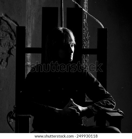 Black and white portrait of man on electric chair  . Dramatic studio lighting