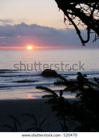Sun glows over pacific at sundown on oregon coast.
