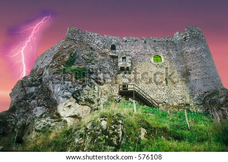 Ancient French castle hewn out of stone with dramatic sky.
