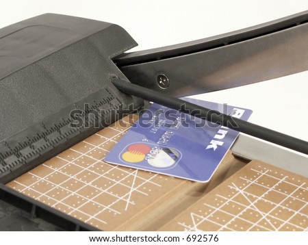 Credit card on cutting board with cutting blade raised.