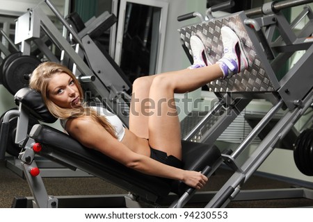 Girl do exercise for legs. in fitness gym looking at the camera