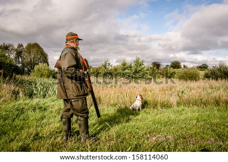 Hunter at a lake, waiting with his dog