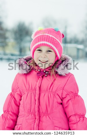 Beautiful happy girl in the red jacket in the winter.