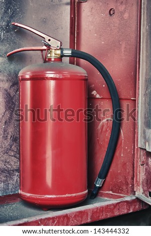 Fire Extinguisher in red cabinet on wall.