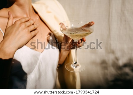 Woman dressed in white dress holding a coupe with a cocktail in sun light. Concept of an open air party. Photo stock © 