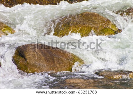 A river blured and looking peaceful rolling over rocks in nature