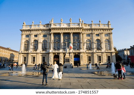 Turin, Italy - 2012 November 2: The Madama Palace at sundown on a sunny day with people in the square in Turin, Italy