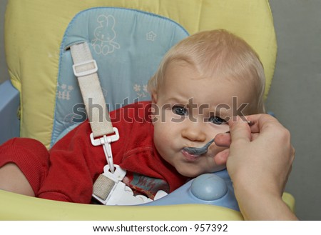amusing baby with a spoon in a mouth