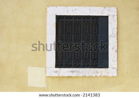 square window with bar, architectural detail of Portuguese house