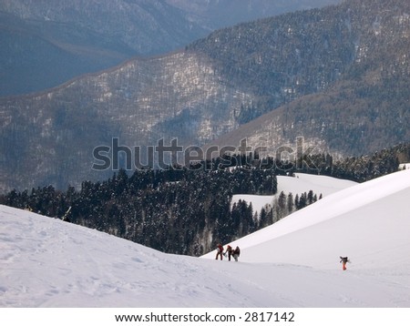 group of skiers and boarders is climbing a mountain. Red Field, Caucasia, Russia.