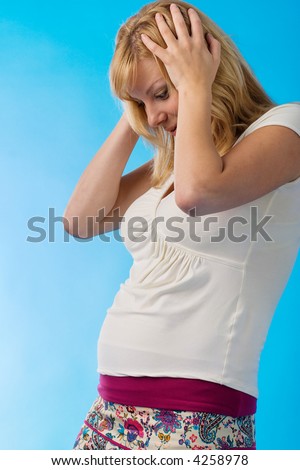 happy surprised pregnant woman on blue background