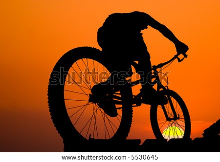 mountain biker silhouette on sea sunset background