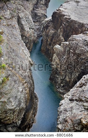 beautiful mountain river in narrow gorge among sheer cliffs, aerial view