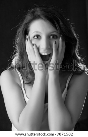 beautiful young girl with happy surprised smile isolated on black