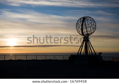 silhouette of globe at Nord Cape of Norway on sunset sky background
