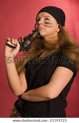beautiful pensive girl in pirate costume with pistol in hand