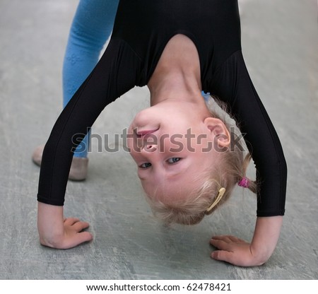 closeup of little gymnast girl doing exercises