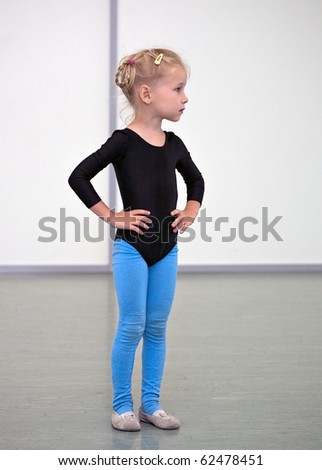 little gymnast girl standing in gym