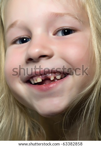 funny smiling little girl without one front tooth